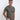 A tall and slim man in the studio standing in front of a light background. The smiling model is wearing an extra long slim dark grey t-shirt in a size medium. The tall dark grey t-shirt features a 3" longer body, 100% organic cotton, and is soft & preshrunk. The dark grey t-shirt is ideal for tall slim men 6'2"+.