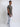 A head to toe shot of a tall slim guy in a studio and wearing a dark grey medium tall slim t-shirt.