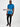 A head to toe shot of a tall slim guy in a studio wearing an azure large tall slim t-shirt and smiling.