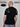 A shot from behind of a tall and slim guy in a studio and wearing a black XL tall slim t-shirt.