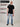A head to toe shot of a tall muscular guy  in a studio and wearing a black XL tall t-shirt.