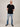 A head to toe shot of a tall and slim guy in the studio wearing a black XL tall slim t-shirt.