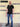 A head to toe shot of a tall slim guy wearing an XL tall black zip polo shirt.