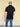 A shot from behind of a tall slim man wearing an XL tall zip polo shirt.