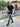 A tall slim man wearing an XL tall black zip polo shirt and walking in a residential compound.
