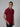 An upper body shot of a tall slim man standing in a studio and wearing a maroon medium tall polo shirt.