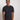 A tall and slim man in the studio standing in front of a light background. The smiling model is wearing an extra long slim charcoal t-shirt in a size medium. The tall charcoal  t-shirt features a 3" longer body, 100% organic cotton, and is soft & preshrunk. The charcoal t-shirt is ideal for tall slim men 6'2"+.