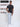 A head to toe shot of a tall slim guy  in a studio and wearing a charcoal medium tall slim t-shirt.
