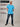 A head to toe shot of a tall slim guy in a studio and wearing a cyan XL tall slim t-shirt.