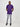 A head to toe shot of a tall slim guy in a studio and wearing a royal purple large tall slim t-shirt, hands behind back.