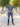 A head to toe shot of a tall athletic guy in a park and wearing an XL tall slim dark slate polo shirt and showing the minimal Just Tall flag logo near the bottom of the side seam.