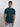 A tall and slim man in the studio standing in front of a light background. The smiling model is wearing an extra long slim dark teal t-shirt in a size medium. The tall dark teal t-shirt features a 3" longer body, 100% organic cotton, and is soft & preshrunk. The dark teal t-shirt is ideal for tall slim men 6'2"+.