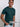 An upper body shot of a tall slim guy  in a studio and wearing a dark teal medium tall t-shirt, hand in pocket.