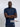 A tall slim man wearing a large tall heavyweight midnight blue t-shirt, arms folded.