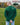 A shot from behind of a tall slim guy in a park wearing an extra long sleeve long sleeve tall t-shirt in green.