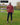 A head to toe shot of a tall athletic guy in a park wearing a dark orange long sleeve tall t-shirt.