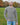 A tall and slim man standing in a park. The smiling model is wearing a light grey long-sleeve tall t-shirt. The tall light grey long-sleeve t-shirt features a 2.5" longer sleeves, 100% organic cotton, and is soft & preshrunk. The light grey long-sleeve t-shirt is ideal for tall slim men 6'2"+.