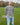 An upper body shot of a tall athletic guy standing in a park wearing a light grey extra long tall long sleeve t-shirt and showing the Just Tall minimalist monogram logo.