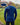 A shot from behind of a tall slim guy in a park wearing an extra long sleeve long sleeve tall t-shirt in navy.