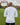 A shot from behind of a tall slim guy in a park wearing an extra long sleeve long sleeve tall t-shirt in white.