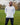 A tall athletic guy wearing a long sleeve white tall t-shirt and smiling in a park with hands behind back.