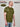 A side shot of a tall and slim guy in a studio and wearing an olive XL tall slim t-shirt.