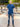 A head to toe shot of a tall athletic man in a park wearing a navy XL tall polo shirt and smiling.
