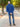 A shot from behind of a tall slim guy in a park wearing an XL tall extra long cobalt quarter zip sweatshirt.