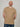 A tall and slim man in the studio standing in front of a light background. The smiling model is wearing an extra long slim tan t-shirt in a size XL. The tall tan t-shirt features a 3" longer body, 100% organic cotton, and is soft & preshrunk. The tan t-shirt is ideal for tall slim men 6'2"+.
