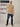 A head to toe shot of a tall slim guy in a studio and wearing a tan XL tall slim t-shirt.