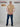 A shot from behind of a tall and athletic guy in a studio and wearing a tan XL tall slim t-shirt.