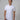 A tall and slim man in the studio standing in front of a light background. The smiling model is wearing an extra long slim white polo shirt in a size M. The tall white polo shirt features a 3" longer body, 100% organic cotton, and is soft & preshrunk. The white polo shirt is ideal for tall slim men 6'2"+.