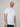 A tall and slim man in the studio standing in front of a light background. The smiling model is wearing an extra long slim white t-shirt in a size XL. The tall white t-shirt features a 3" longer body, 100% organic cotton, and is soft & preshrunk. The white t-shirt is ideal for tall slim men 6'2"+.