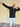 A tall slim man wearing a tall black full zip hoodie and striking a super star pose and laughing.