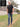 A head to toe shot of a tall skinny guy wearing a tall black henley shirt.