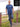A head to toe shot of a tall slim guy in an L tall graphic t-shirt with a lake design.
