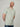 A tall and slim guy in the studio, hands behind back and wearing a sage green XL tall slim v-neck t-shirt.